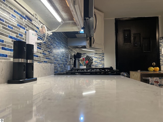 kitchen featuring light stone countertops and tasteful backsplash