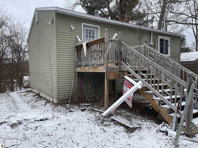 snow covered house featuring a deck