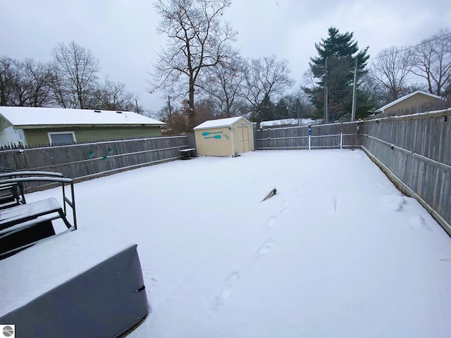 snowy yard featuring a shed