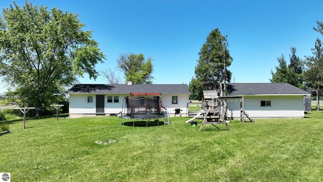 back of house with a playground, a yard, and a trampoline