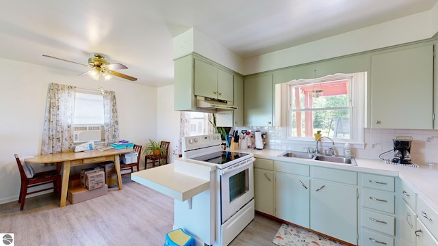 kitchen with sink, white electric stove, light hardwood / wood-style flooring, ceiling fan, and decorative backsplash