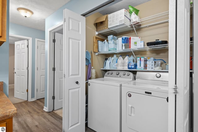 laundry room featuring light hardwood / wood-style flooring and washing machine and clothes dryer