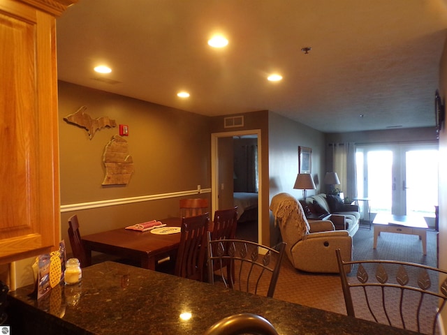 carpeted dining room with french doors