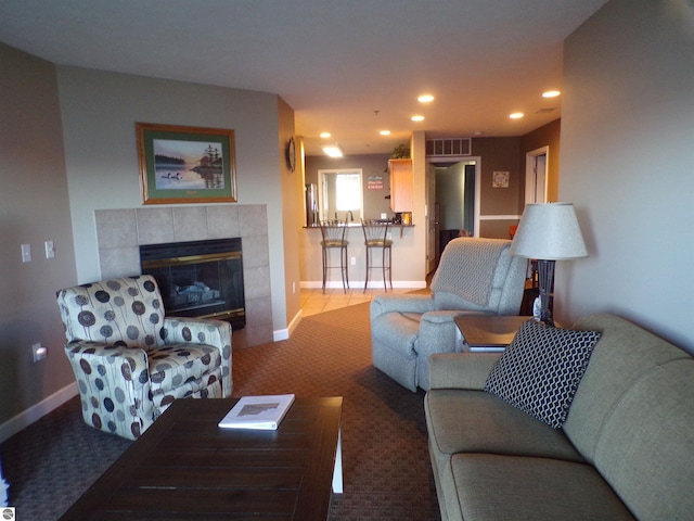 living room with carpet floors and a tile fireplace