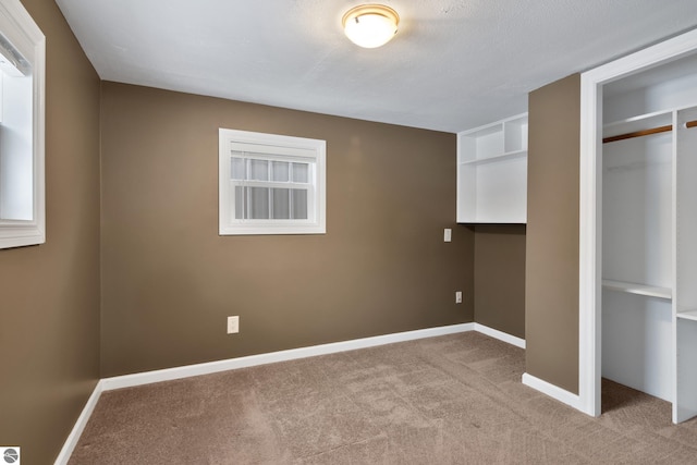 unfurnished bedroom with light carpet and a closet