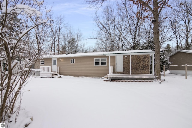 view of snow covered back of property