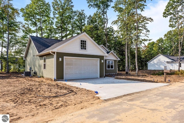 view of front of home featuring cooling unit and a garage