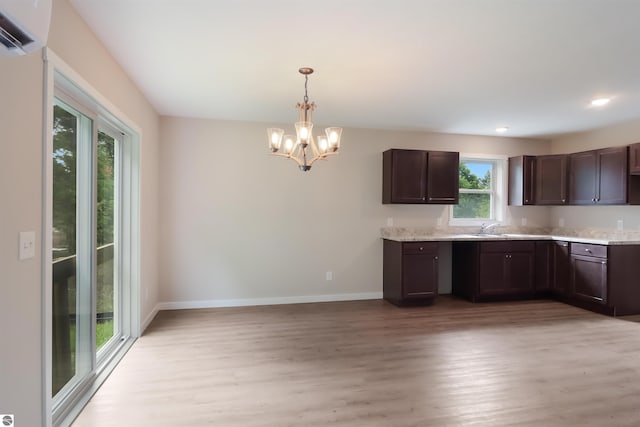 kitchen featuring dark brown cabinets, light hardwood / wood-style floors, decorative light fixtures, and an inviting chandelier