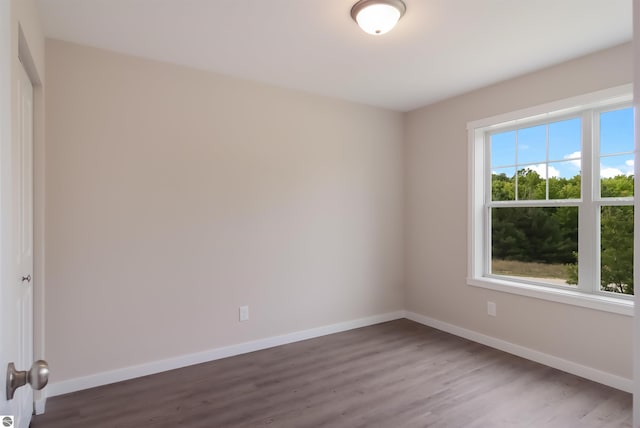 empty room with dark hardwood / wood-style flooring