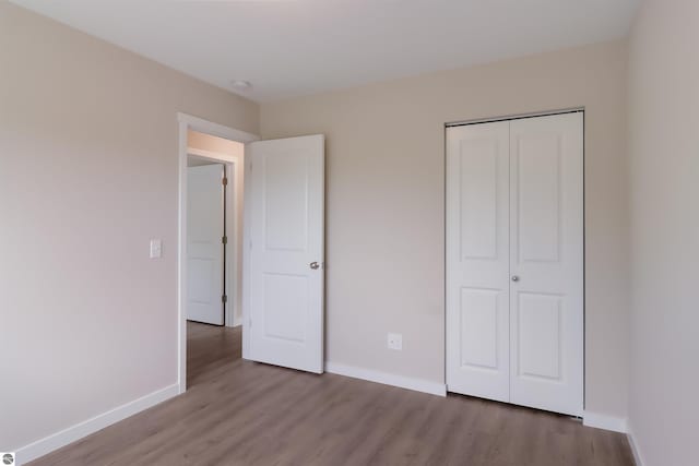 unfurnished bedroom with light wood-type flooring and a closet