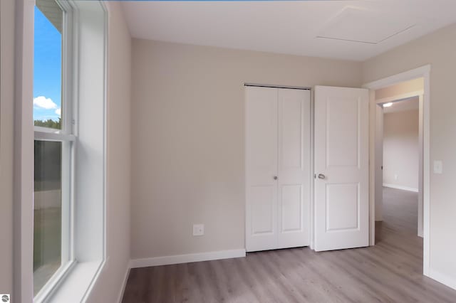 unfurnished bedroom with light hardwood / wood-style floors and a closet