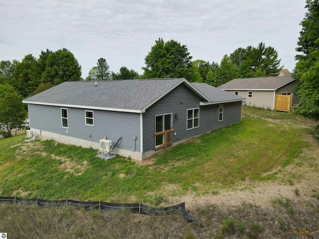 back of house with ac unit and a lawn