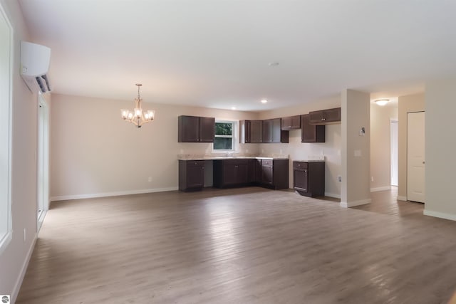 kitchen featuring dark brown cabinetry, light hardwood / wood-style flooring, a notable chandelier, a wall mounted AC, and decorative light fixtures