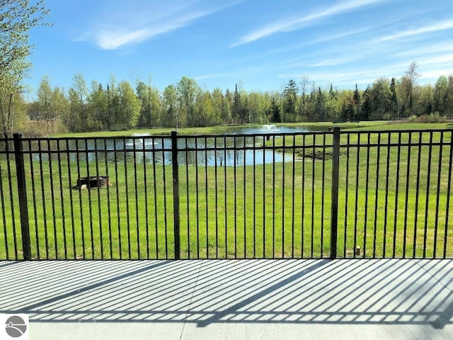 view of gate with a water view and a lawn