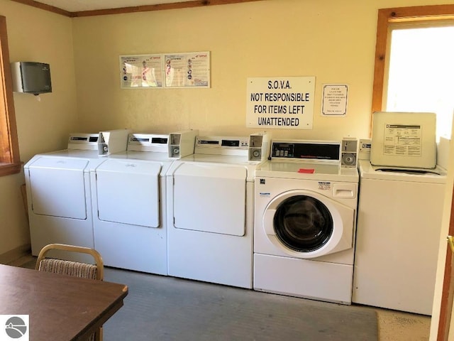 laundry room with washing machine and dryer and ornamental molding