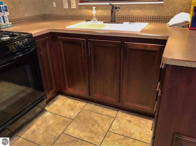 kitchen featuring black range, sink, and tasteful backsplash