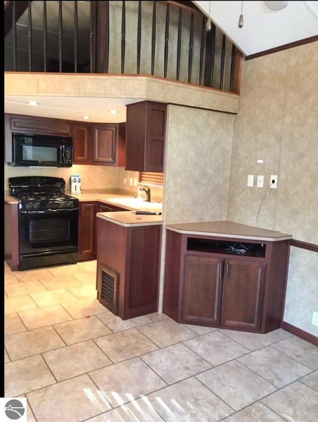 kitchen with sink, a towering ceiling, and black appliances