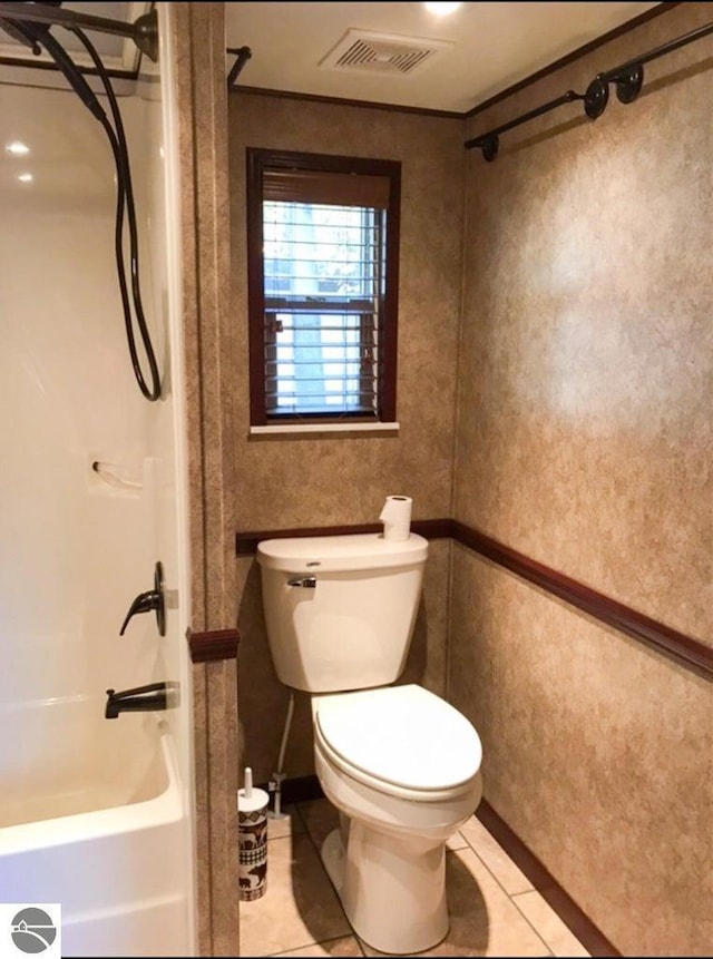 bathroom featuring tile patterned floors, shower / tub combination, and toilet