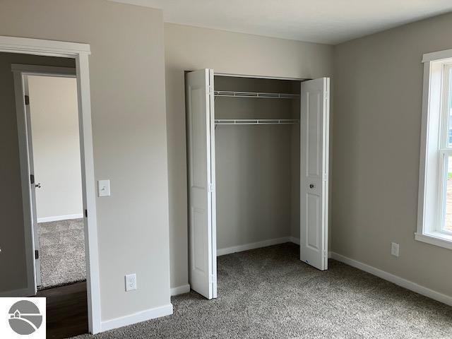 unfurnished bedroom with carpet flooring and a closet