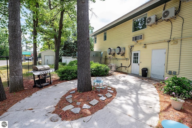 view of patio with ac unit, a storage unit, and a grill