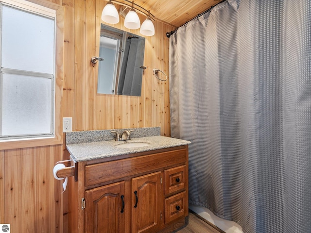 bathroom with vanity, wooden walls, and wood ceiling