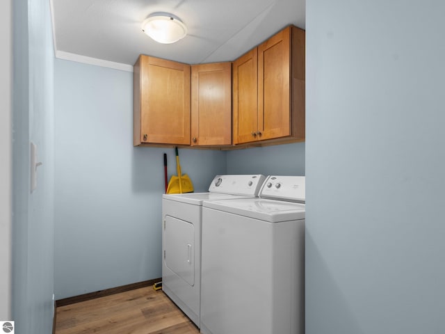 laundry room featuring crown molding, cabinets, independent washer and dryer, and light wood-type flooring