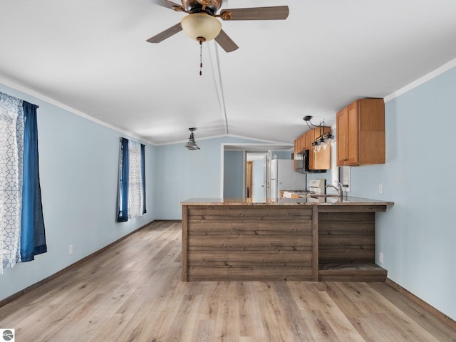 kitchen featuring white refrigerator, vaulted ceiling, light wood-type flooring, ornamental molding, and kitchen peninsula