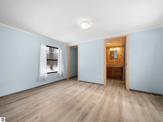 unfurnished bedroom with ornamental molding, sink, connected bathroom, and light hardwood / wood-style flooring