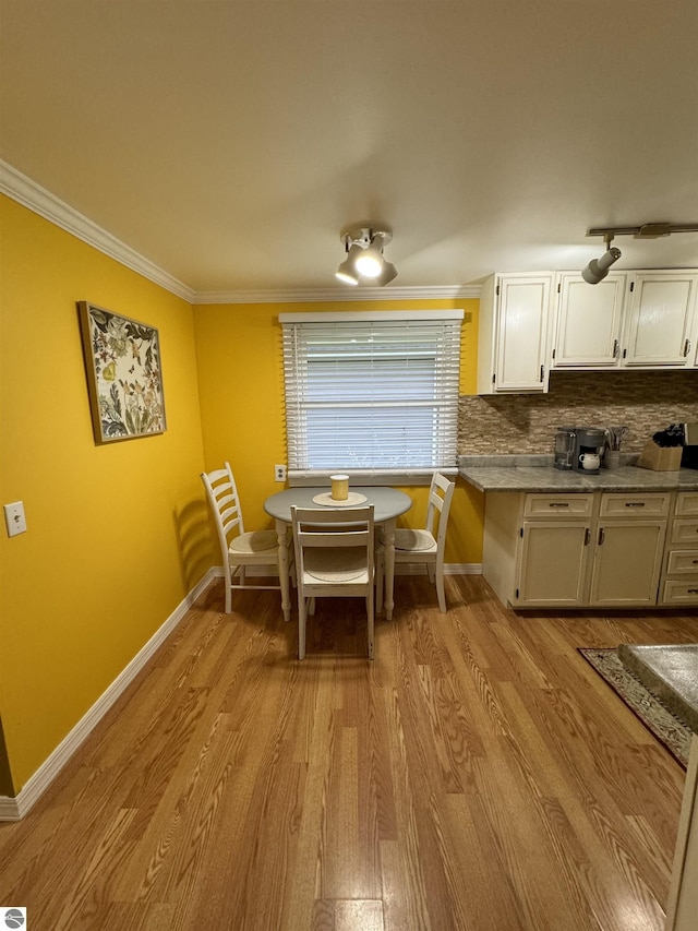 dining space with light wood-type flooring and crown molding