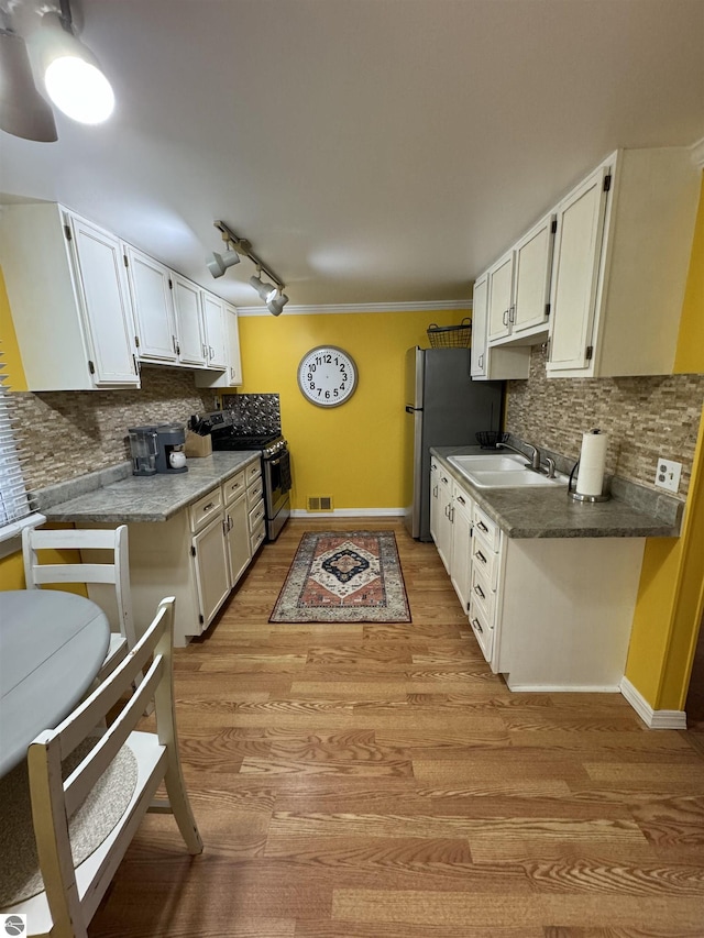 kitchen featuring white cabinetry, light wood-type flooring, sink, and stainless steel range