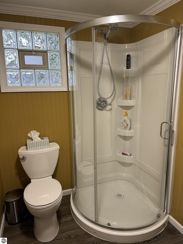 bathroom featuring hardwood / wood-style floors, toilet, an enclosed shower, and ornamental molding