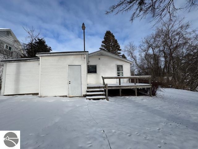 snow covered property with a deck