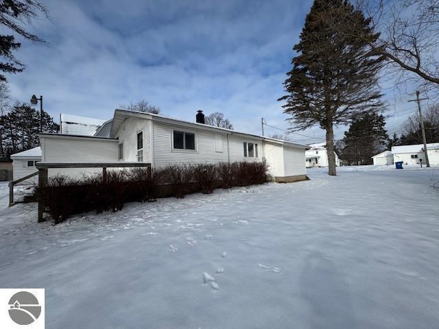 view of snow covered rear of property