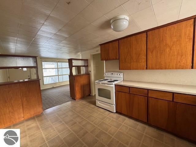 kitchen featuring light colored carpet and white electric stove