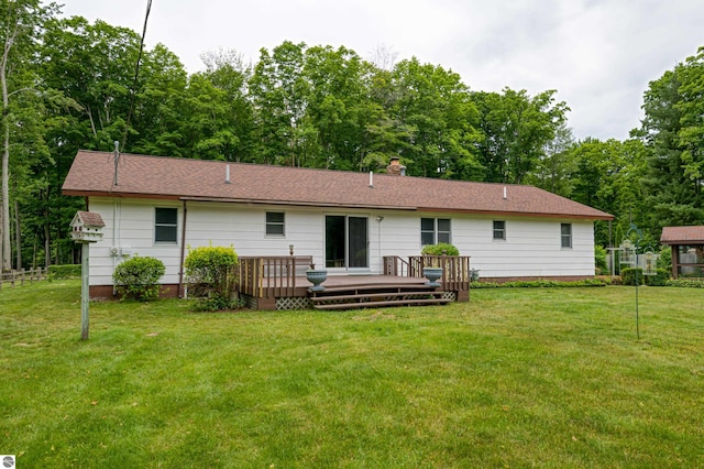 rear view of house featuring a lawn and a wooden deck