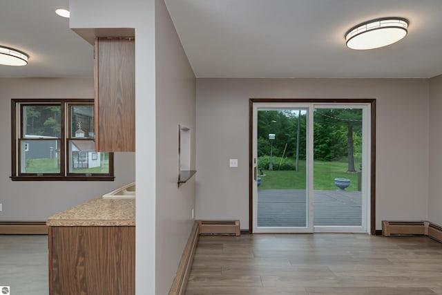 entryway featuring light wood-type flooring, sink, and a baseboard radiator