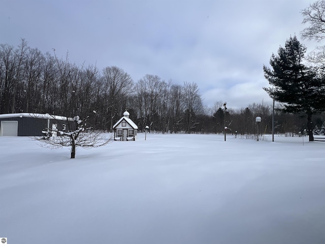 snowy yard featuring an outbuilding