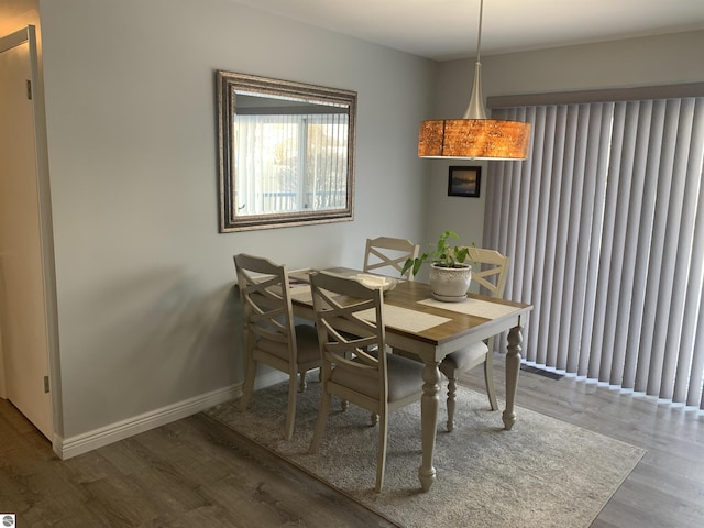 dining space with baseboards and wood finished floors