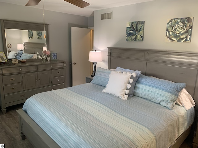 bedroom featuring dark wood-style floors, visible vents, and a ceiling fan