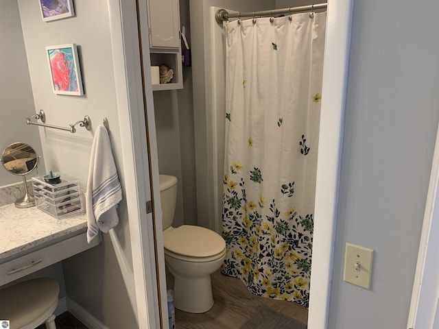 full bath with a shower with shower curtain, wood finished floors, and toilet