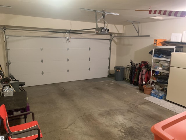 garage with a garage door opener and freestanding refrigerator