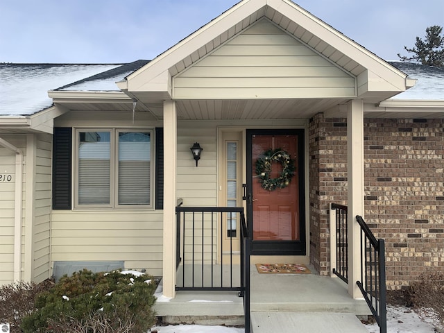 view of exterior entry featuring brick siding