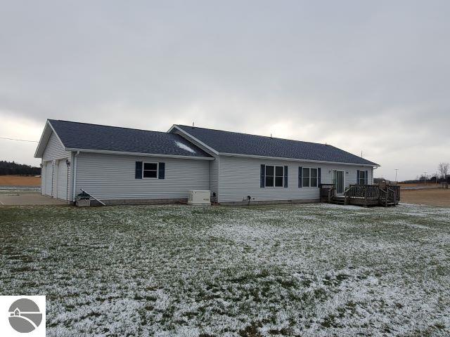 back of property with a garage and a deck