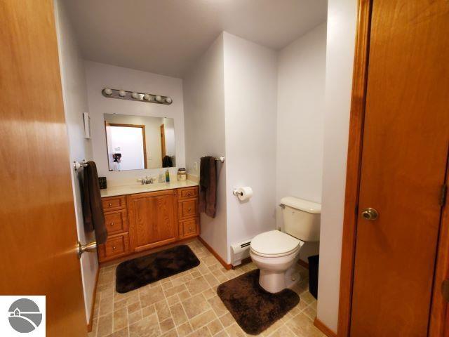 bathroom with vanity, toilet, and baseboard heating