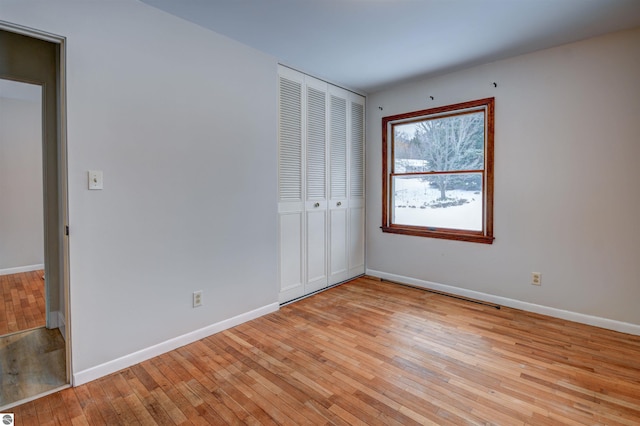 unfurnished bedroom featuring light hardwood / wood-style floors and a closet