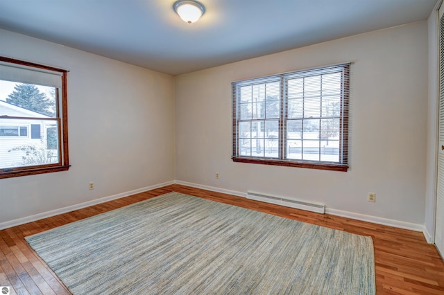 spare room with hardwood / wood-style floors and a baseboard radiator