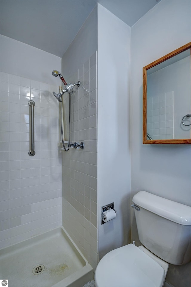 bathroom featuring toilet and a tile shower