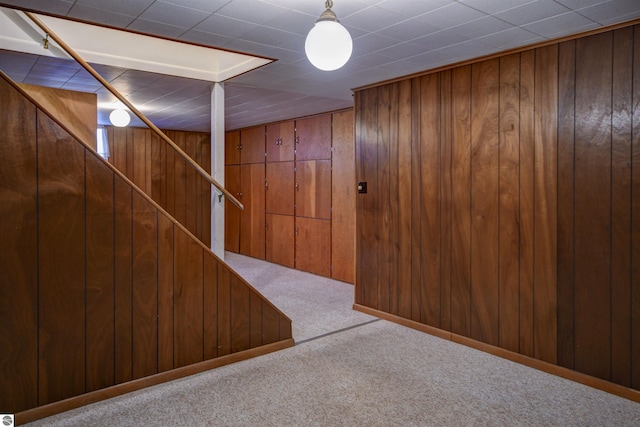 basement featuring carpet and wooden walls