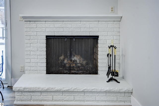 room details featuring hardwood / wood-style floors and a brick fireplace