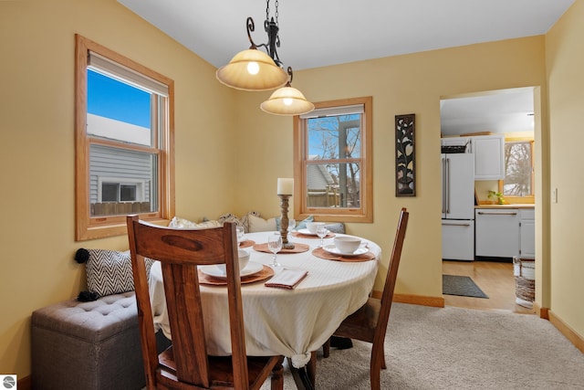 dining area with plenty of natural light and light carpet